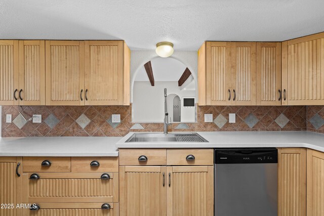 kitchen featuring dishwasher, backsplash, light countertops, light brown cabinets, and a sink