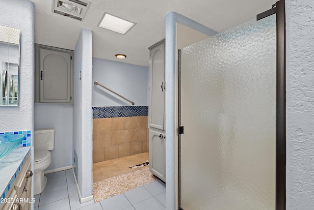 full bathroom with a stall shower, tile patterned flooring, visible vents, and vanity