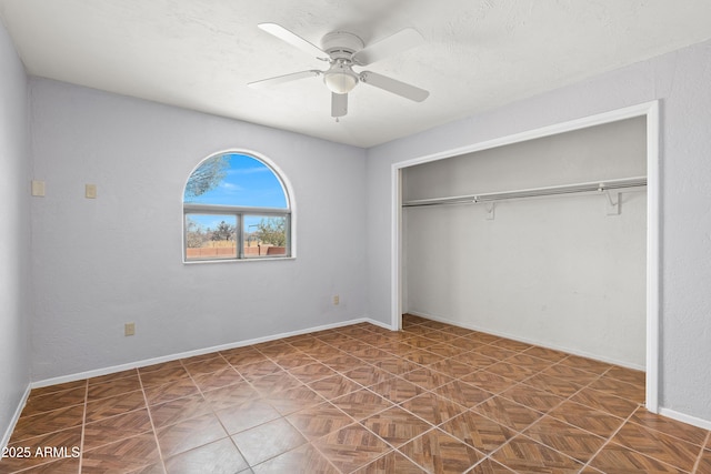 unfurnished bedroom featuring baseboards, a textured ceiling, a ceiling fan, and a closet