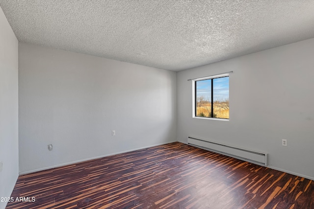 spare room with a textured ceiling, baseboard heating, and wood finished floors