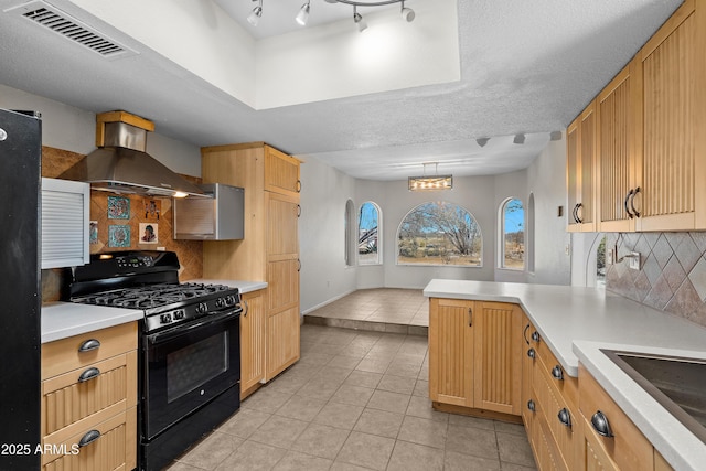 kitchen with light tile patterned flooring, visible vents, light countertops, wall chimney exhaust hood, and black gas range oven