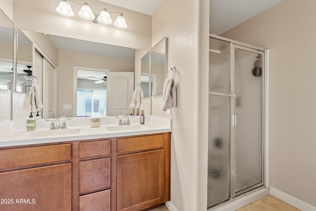 bathroom with a shower with door, vanity, tile patterned flooring, and ceiling fan