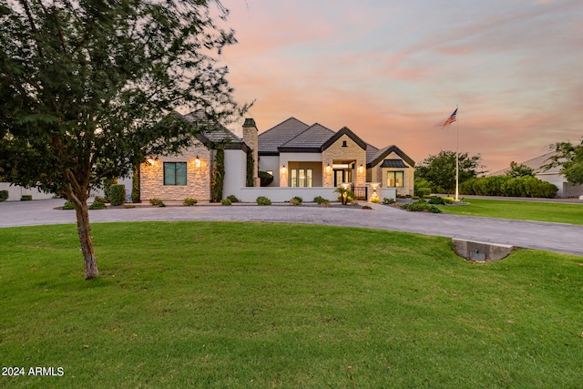 french country inspired facade with a yard