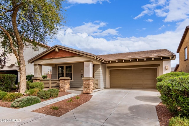 view of front facade featuring an attached garage, covered porch, stone siding, and concrete driveway