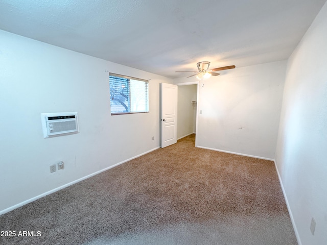 carpeted spare room featuring ceiling fan and a wall mounted air conditioner