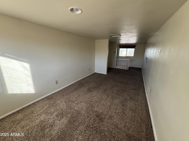 unfurnished room featuring dark carpet