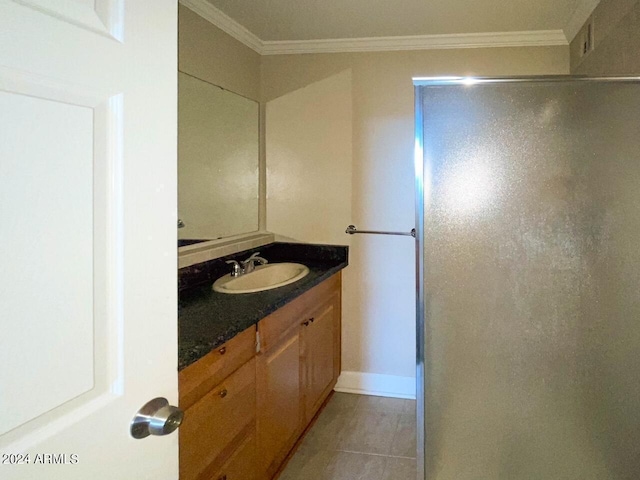 bathroom featuring tile patterned flooring, crown molding, and vanity