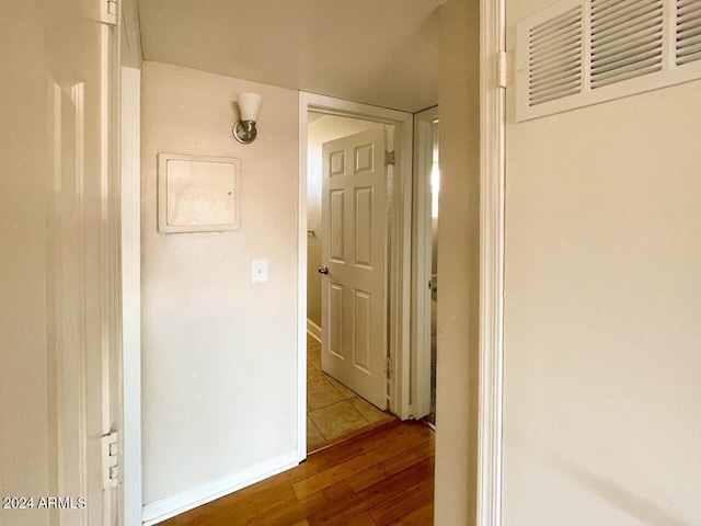 corridor with hardwood / wood-style flooring