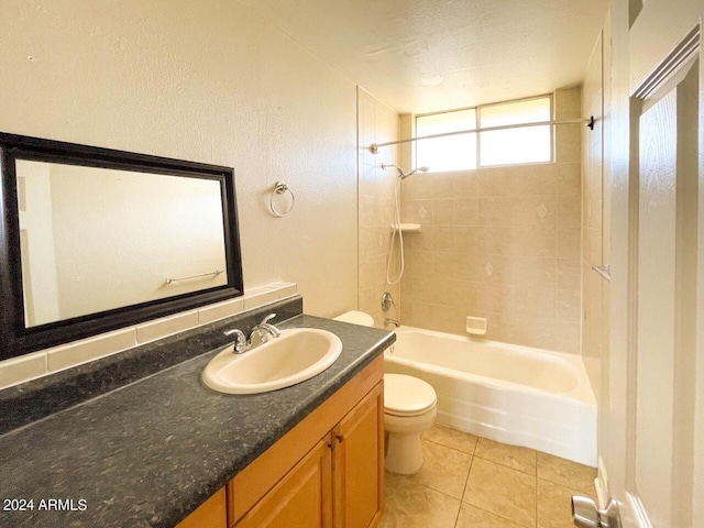 full bathroom with vanity, tiled shower / bath, toilet, a textured ceiling, and tile patterned flooring