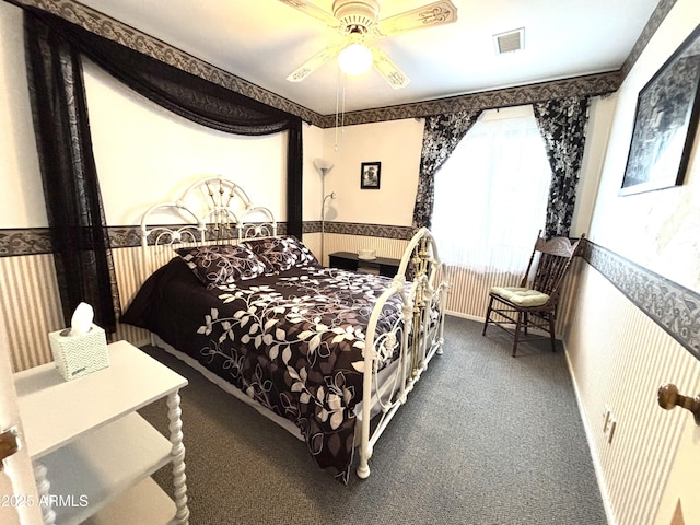 bedroom featuring wallpapered walls, carpet, visible vents, and wainscoting