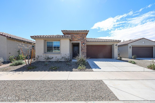 mediterranean / spanish-style house with concrete driveway, a tiled roof, a garage, and stucco siding