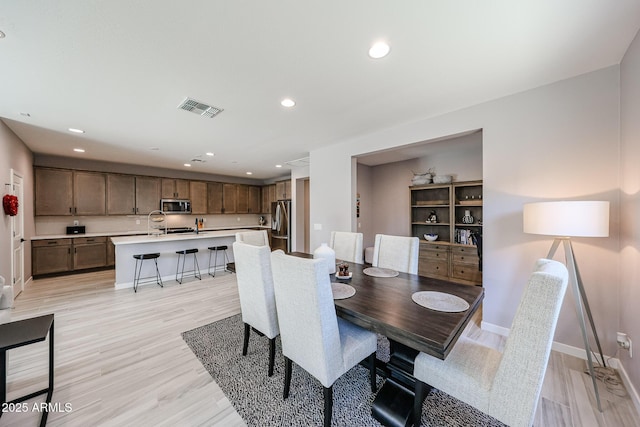 dining space with recessed lighting, visible vents, light wood finished floors, and baseboards