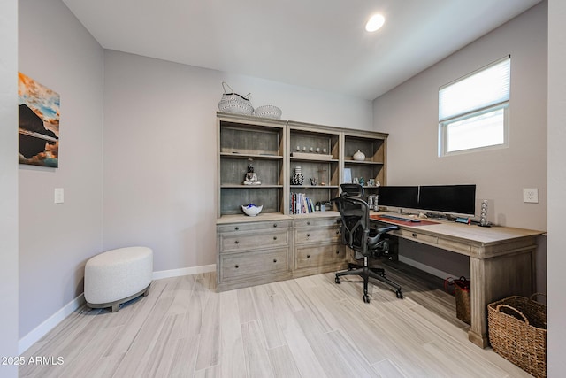 home office with light wood-style flooring and baseboards