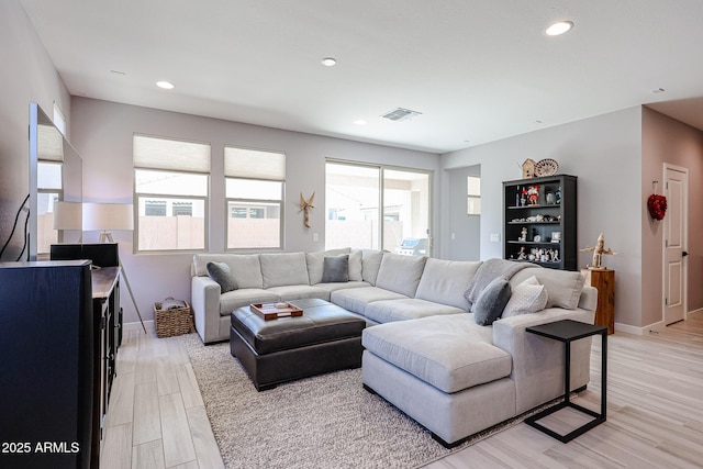 living area featuring light wood-type flooring, visible vents, baseboards, and recessed lighting