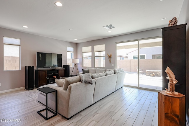 living area featuring light wood-style flooring, recessed lighting, and visible vents