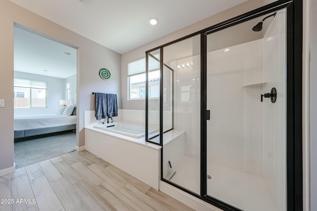 bathroom with a stall shower, baseboards, a garden tub, and ensuite bath