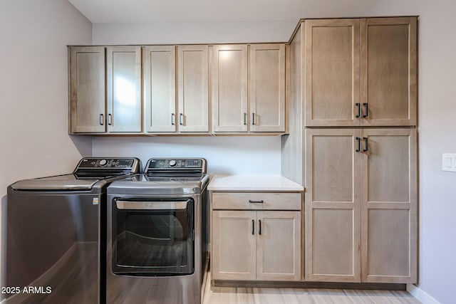 laundry area featuring baseboards, cabinet space, and washing machine and dryer