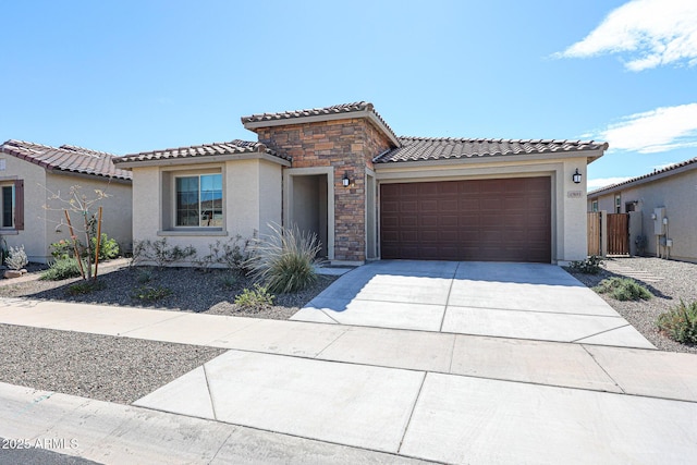 view of front of property featuring an attached garage, stucco siding, concrete driveway, stone siding, and a tiled roof