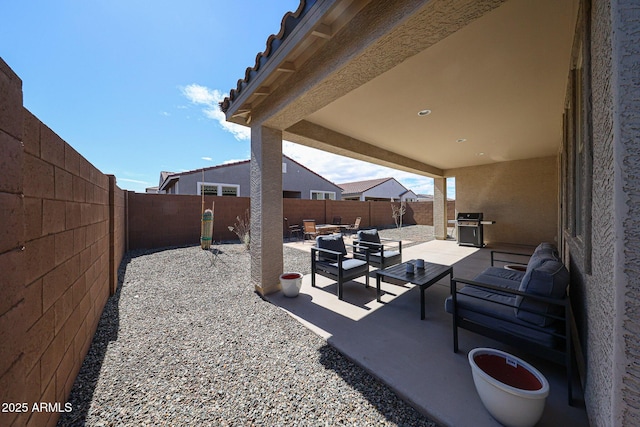 view of patio with grilling area, an outdoor living space, and a fenced backyard