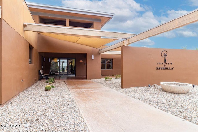 view of exterior entry featuring stucco siding