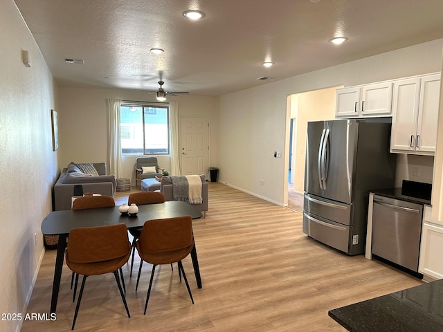 dining space featuring ceiling fan, light hardwood / wood-style flooring, and a textured ceiling