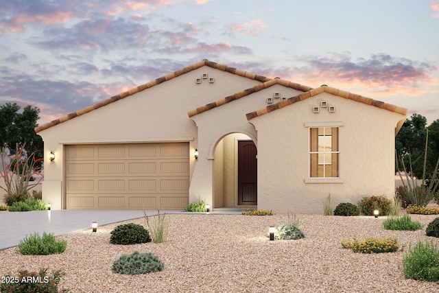mediterranean / spanish home with an attached garage, stucco siding, and concrete driveway