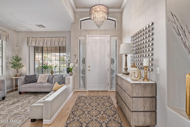 21474 N 56th Ave, Glendale, AZ 85308 - foyer featuring baseboards, an inviting chandelier, crown molding, light wood-style floors, and visible vents