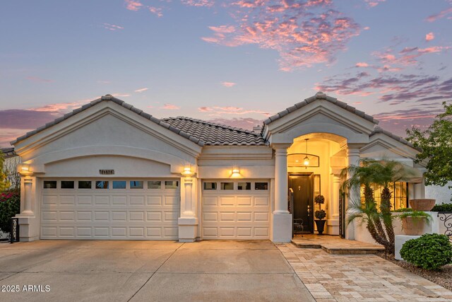 21474 N 56th Ave, Glendale, AZ 85308 - mediterranean / spanish-style home featuring an attached garage, driveway, stucco siding, and a tile roof