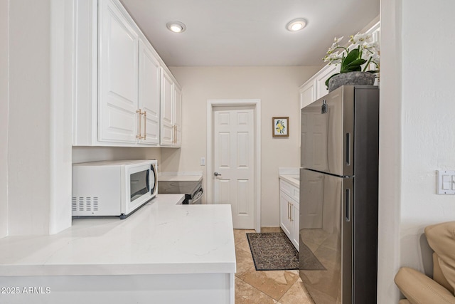 21474 N 56th Ave, Glendale, AZ 85308 - kitchen featuring recessed lighting, a peninsula, white cabinets, light stone countertops, and stainless steel appliances