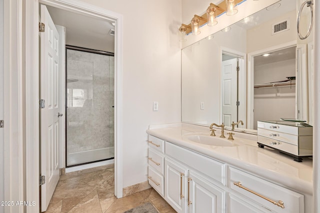 21474 N 56th Ave, Glendale, AZ 85308 - bathroom with visible vents, baseboards, vanity, and a shower with door