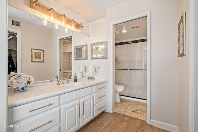 21474 N 56th Ave, Glendale, AZ 85308 - full bathroom featuring a shower stall, vanity, visible vents, toilet, and wood finished floors