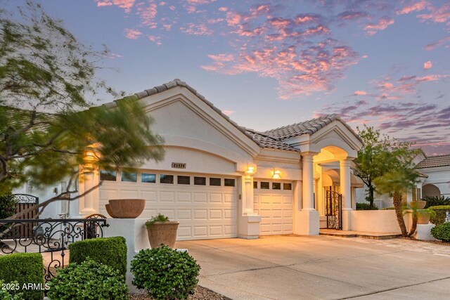 21474 N 56th Ave, Glendale, AZ 85308 - view of front of house featuring an attached garage, driveway, stucco siding, and a tile roof