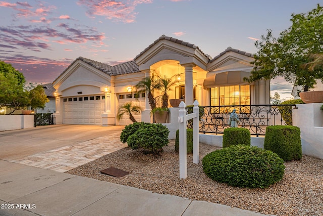 21474 N 56th Ave, Glendale, AZ 85308 - mediterranean / spanish home featuring concrete driveway, stucco siding, a tiled roof, and an attached garage