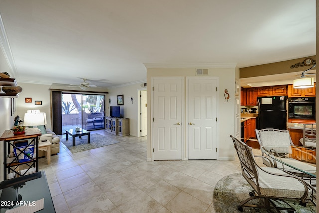 living room with ornamental molding, ceiling fan, and light tile floors