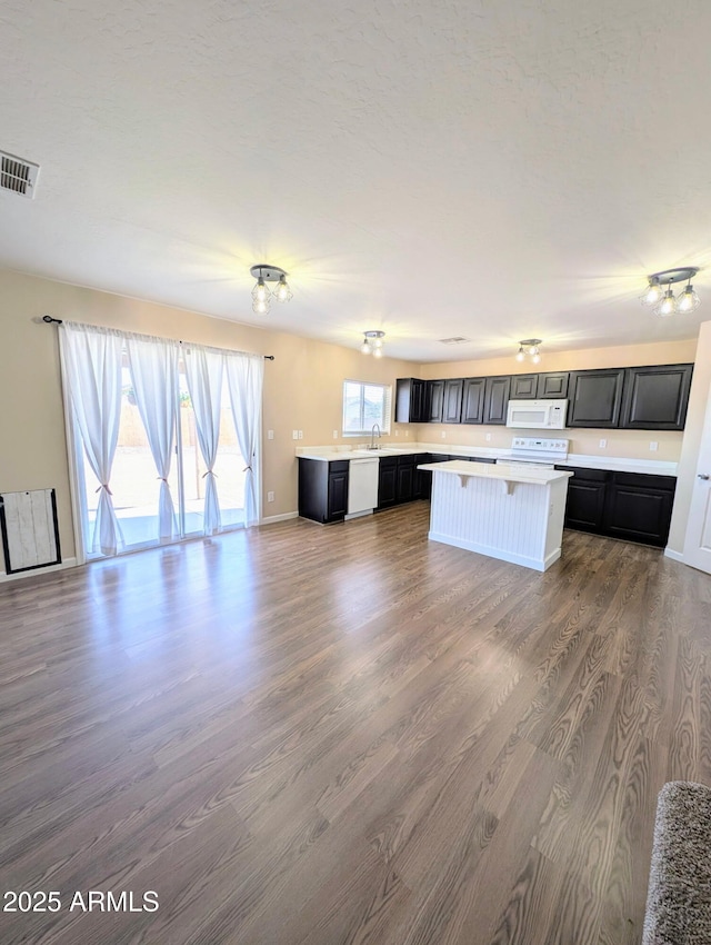 22523 W Pima St, Buckeye, AZ 85326 - kitchen featuring white appliances, light countertops, dark wood finished floors, a center island, and open floor plan