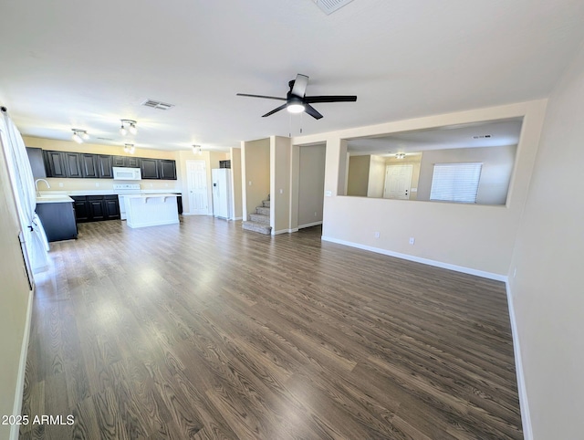 22523 W Pima St, Buckeye, AZ 85326 - unfurnished living room with dark wood-style flooring, stairs, and ceiling fan