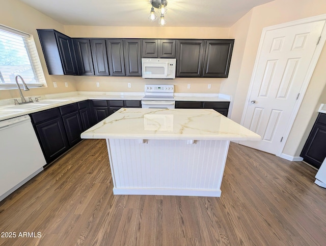 22523 W Pima St, Buckeye, AZ 85326 - kitchen with white appliances, wood finished floors, light stone counters, and a kitchen island