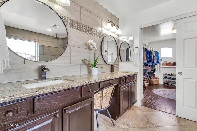 21167 E Aspen Valley Dr, Queen Creek, AZ 85142 - full bathroom with double vanity, decorative backsplash, a spacious closet, tiled shower, and tile patterned floors