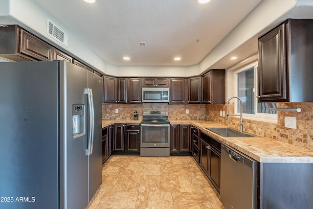 215 S 132nd St, Chandler, AZ 85225 - kitchen featuring stainless steel appliances, dark brown cabinets, light countertops, backsplash, and recessed lighting