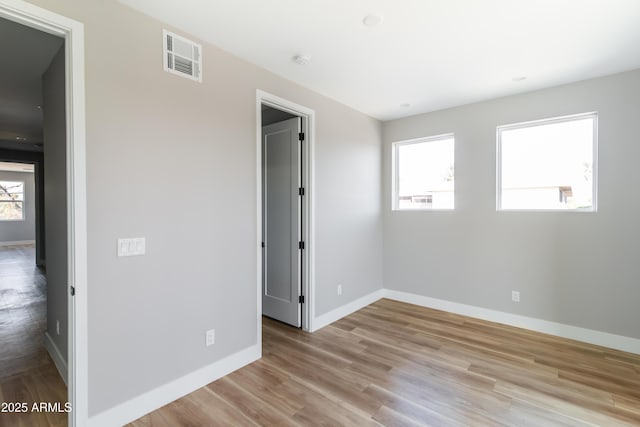 spare room featuring plenty of natural light and light wood-type flooring