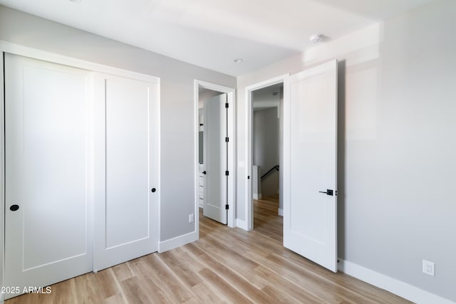 unfurnished bedroom with a closet and light wood-type flooring