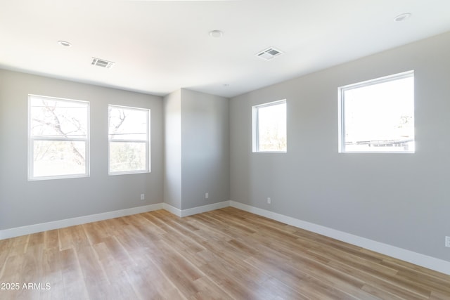 spare room with light hardwood / wood-style flooring and plenty of natural light