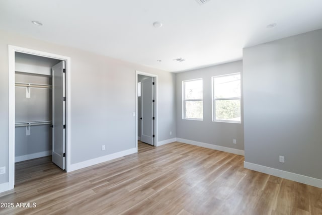 unfurnished bedroom with light hardwood / wood-style floors and a closet