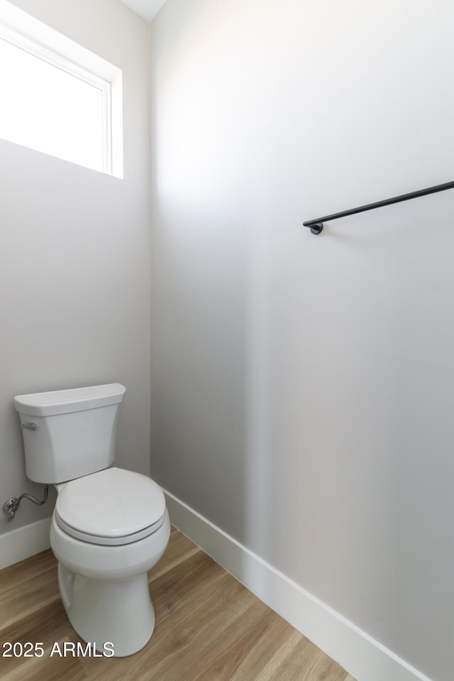 bathroom featuring wood-type flooring and toilet