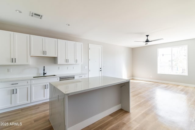 kitchen featuring sink, white cabinets, and a kitchen island