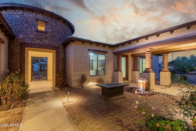 patio terrace at dusk featuring an outdoor fire pit