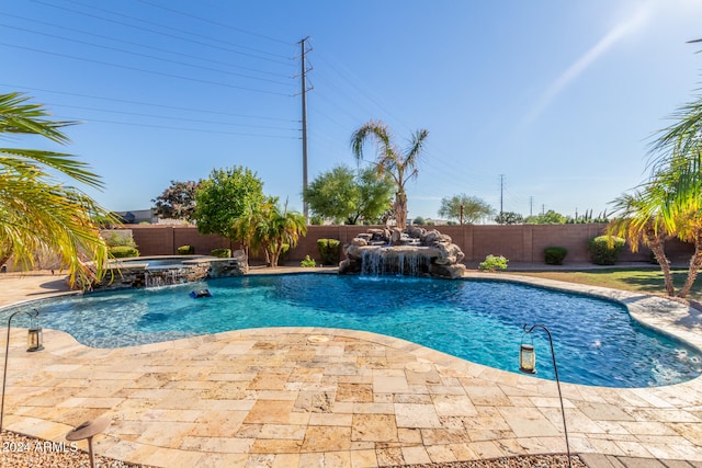 view of pool featuring an in ground hot tub, pool water feature, and a patio area