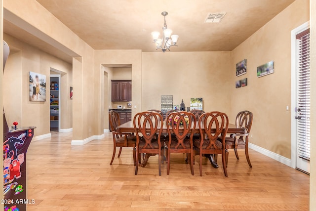 dining area featuring a notable chandelier and light wood-type flooring