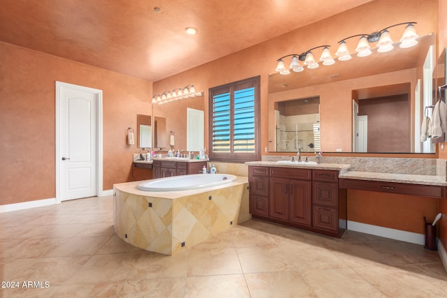 bathroom featuring vanity, tiled bath, and tile patterned flooring