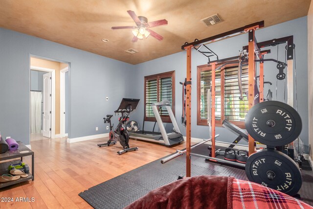 workout area featuring ceiling fan and hardwood / wood-style flooring